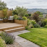 A compact timber deck with built-in planter beside a lawn, path, and planted border.