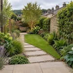 A narrow garden with crosswise paving, deep planted borders, and a bench at the far end.