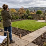 A homeowner surveys a garden layout marked with string before landscaping work begins.