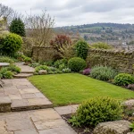 A practical Shipley garden layout with stone path, lawn, planting and a small seating area.