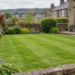 A naturally mown Shipley lawn with flower borders and a West Yorkshire stone garden edge.
