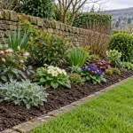 A weeded Shipley garden border with hardy seasonal plants set in prepared soil.